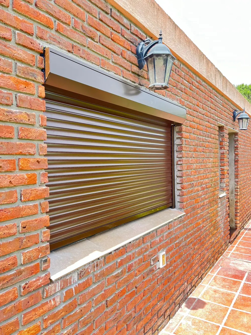 Cortina de enrollar de aluminio instalada sobre una ventana en una casa de Montevideo